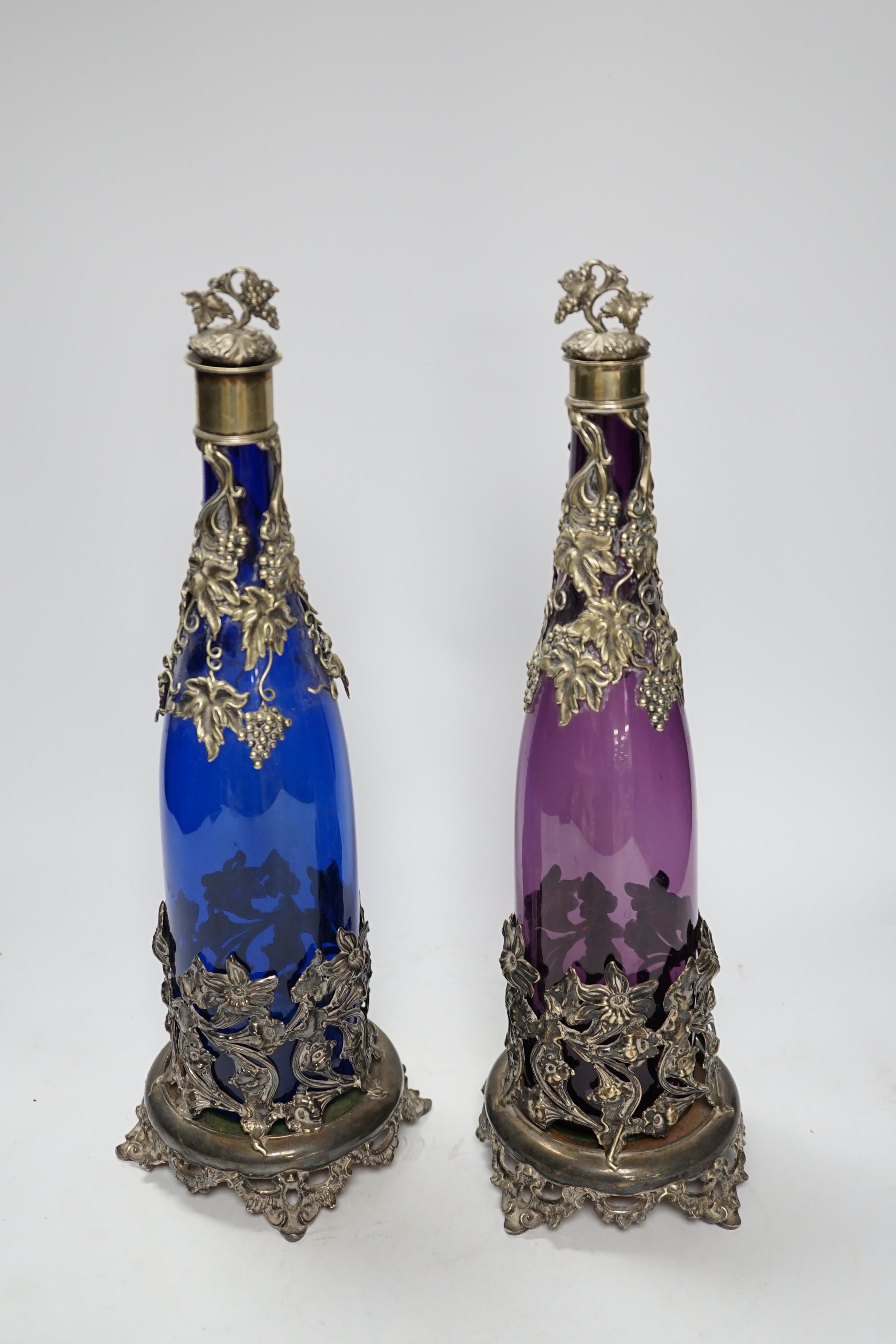 A pair of Victorian coloured glass decanters with silver plated stoppers and mounts, 38cm high